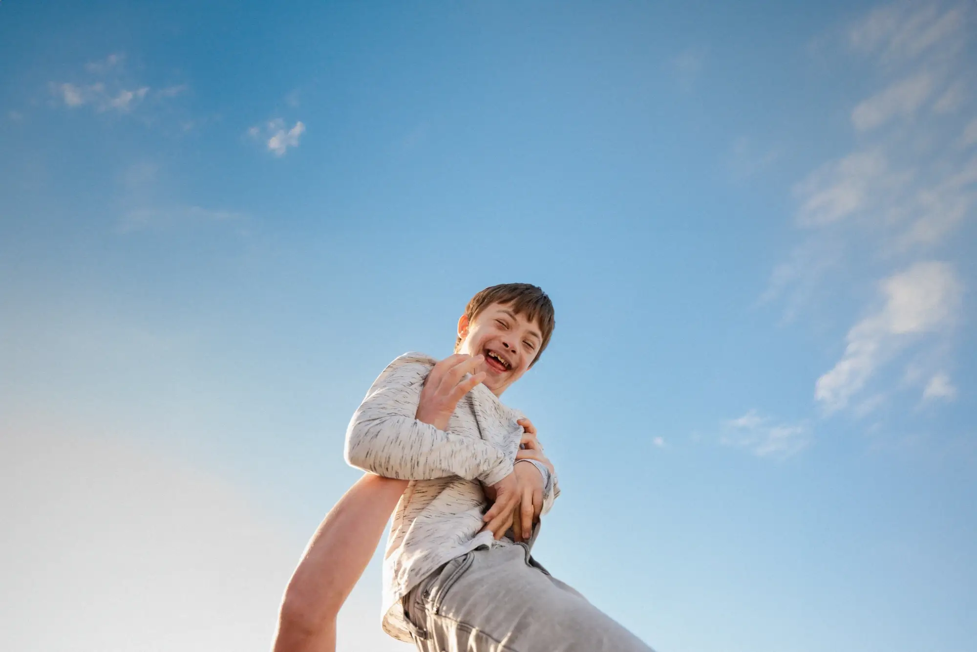 Alexander is lifted up into the blue sky and illuminated by the sun from the left side.